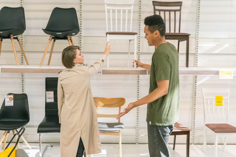 A couple explores chair options together in a modern furniture store during the day.