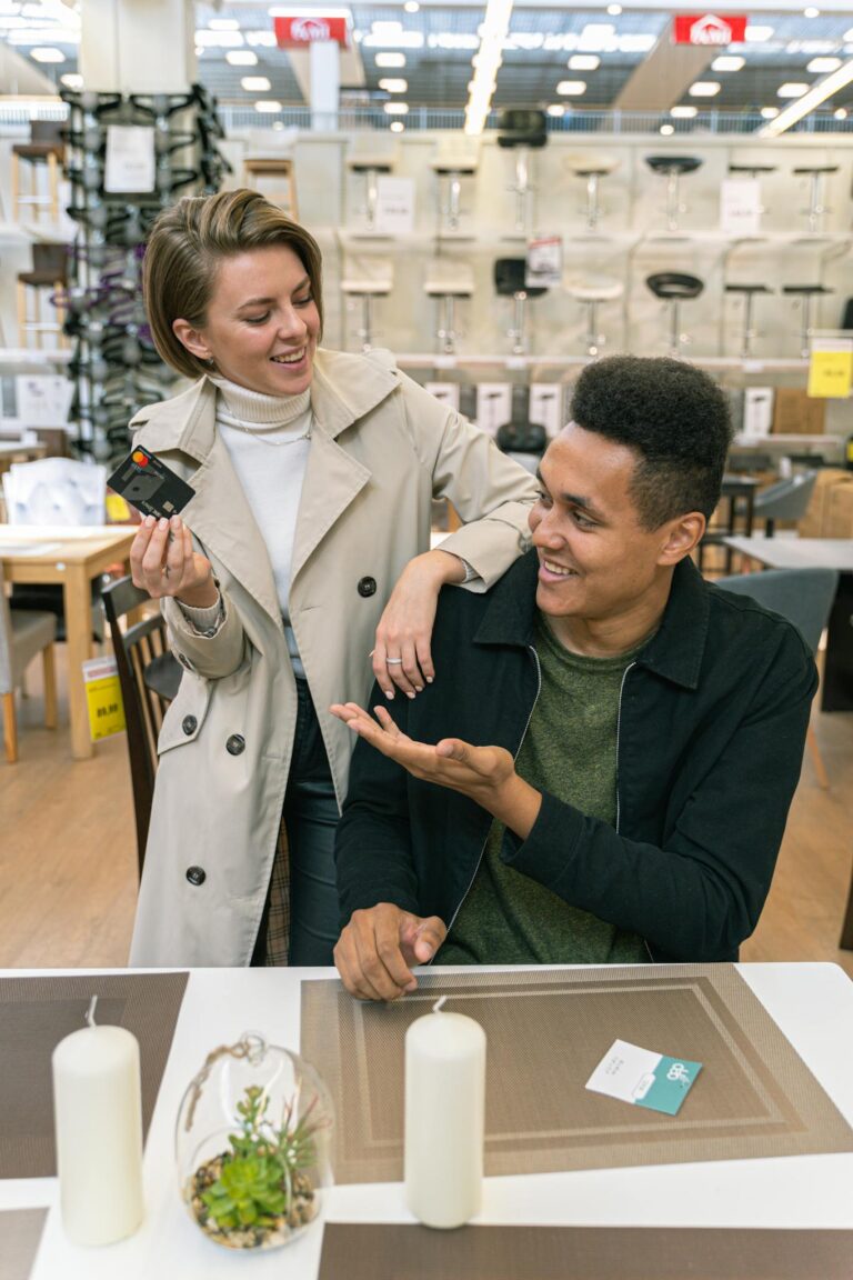 A young couple shopping in a contemporary furniture store, making payment with a credit card.